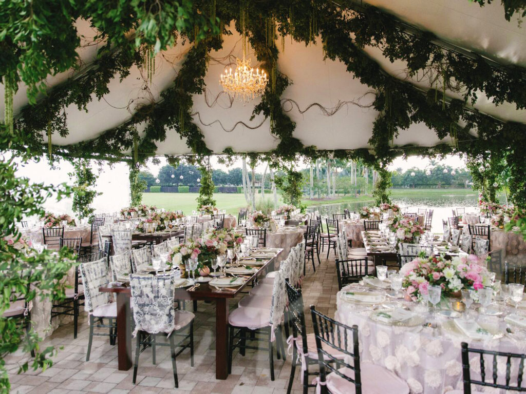 Garland-Draped Ceiling: Outdoor tented wedding with green garlands